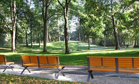 Das Foto zeigt drei Parkbänke mit Blick auf den freigelegten Hügel