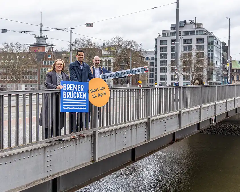 Freuen sich über die Wiederaufnahme des Straßenbahnverkehrs auf der Brücke: Mobilitätssenatorin Özlem Ünsal (v.l.), Rick Graue, Leiter des Amtes für Straßen und Verkehr, sowie Lars Dege, Fachbereichsleiter Verkehrs- und Angebotsplanung bei der BSAG.