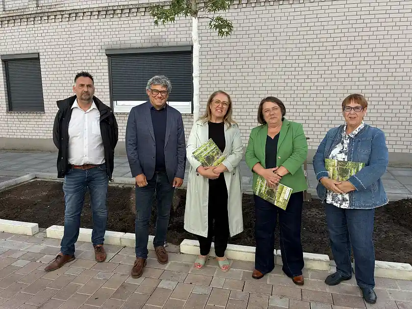 Akteure der klimaangepassten Vorbildstraße in Gröpelingen stehen vor einem frisch gepflanzten Baum
