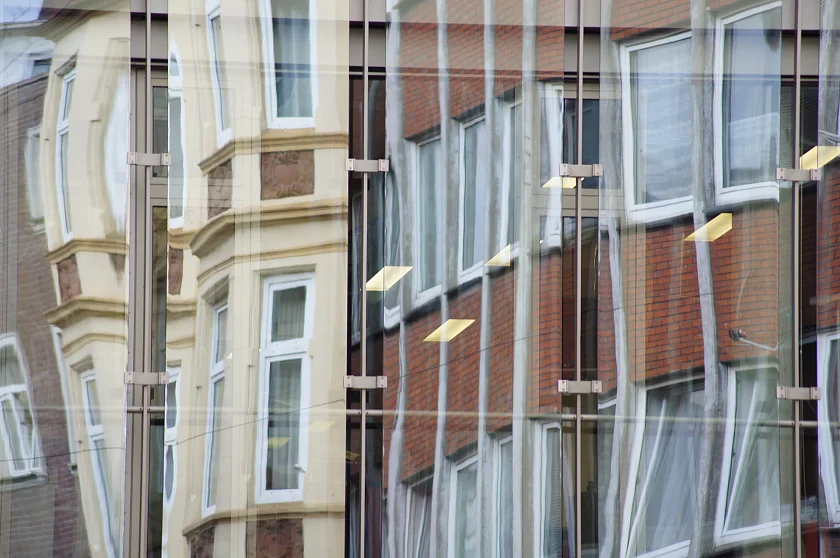 Häuserzeile spiegelt sich in Glasfront