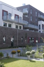 Vorgärten der Reihenhäsuer und Rückfront des GEWOBA Neubaus