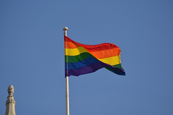 Regenbogenfahne vor blauem Himmel