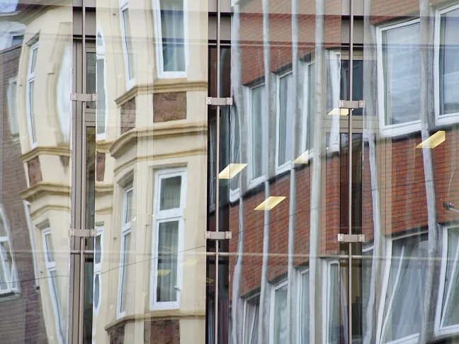 Häuserzeile wird in Glasfront gespiegelt (Symbolbild)