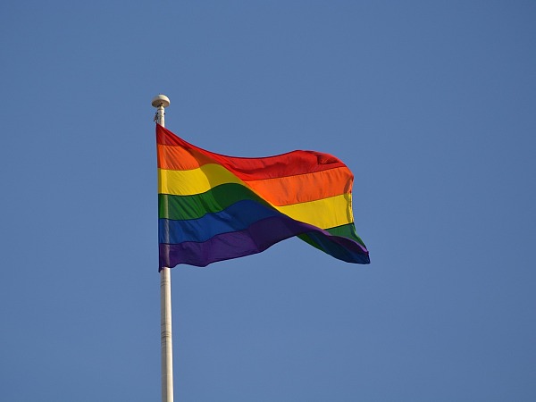 Regenbogenfahne vor blauem Himmel